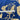 A close-up of a blue fabric with a beige botanical leaf pattern, with a white measuring tape laid horizontally across the middle to indicate scale.