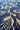 A close-up of a blue fabric with a gold floral and leaf pattern.