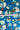 A close-up of a blue fabric with a retro mid-century modern floral and abstract pattern, featuring a white measuring tape ruler laid horizontally across the center to indicate scale.