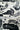 Black and white patterned fabric featuring stylized birds, clouds, and floral motifs, shown with a measuring tape across the middle to indicate scale.