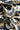 A close-up of draped fabric with a bold black and off-white print featuring stylized birds, clouds, and abstract line motifs.
