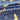 A close-up of draped fabric with a bold floral pattern in navy blue and warm cream.