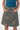 A woman wearing a teal sleeveless top and a knee-length A-line skirt with a geometric pattern in muted blue-gray and beige. The skirt has side pockets and is shown against a plain white background.