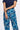 A person wearing blue wide-leg trousers with a colorful geometric semicircle pattern, 