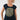 A smiling woman with curly blonde hair wearing a navy blue scoop-neck t-shirt with a large olive green and white sunburst graphic on the front, 