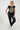 A woman modeling a navy blue short-sleeve t-shirt with a large gold sunburst graphic on the front