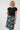 a black short-sleeve top and a knee-length navy skirt with a multicolor abstract cloud-like pattern,