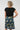 A woman shown from the back wearing a black short-sleeve top and a dark teal A-line skirt with a colorful abstract pattern 