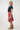A woman modeling a red A-line skirt with a colorful retro abstract pattern, 