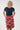 A woman modeling a red knee-length skirt with a colorful abstract pattern of circles, waves, 