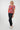 A woman modeling a red short-sleeve t-shirt with a colorful abstract pattern, 