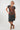 A woman modeling a dark gray t-shirt with a rust-orange abstract pattern, 