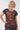 A smiling blonde woman wearing a dark charcoal gray t-shirt with a rust-orange abstract pattern, 