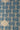 A close-up of a woven textile  pattern featuring a repeating geometric design in dark blue on a natural beige linen-like background.