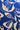 A close-up of a fabric or wallpaper pattern featuring cream-colored botanical leaf and flower silhouettes printed on a rich royal blue background.