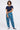 A woman modeling a pair of blue patterned pants with a navy t-shirt and navy sneakers, 