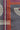 A close-up of a textured gray quilt with geometric patterns including orange, magenta, and cream stripes and curved lines.