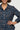 Woman wearing a navy blue patterned shirt against a plain background