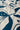 A close-up of a fabric surface with an abstract botanical pattern in dark teal-blue on an off-white background.
